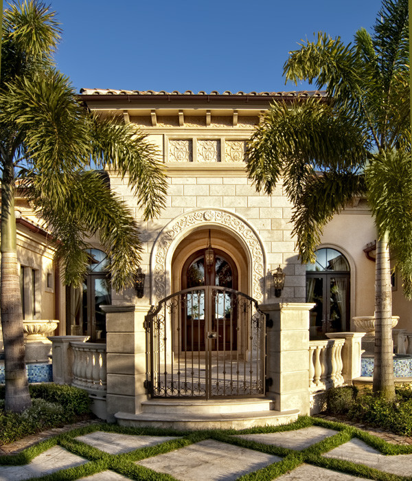 Esempio della facciata di una casa grande beige mediterranea a un piano con rivestimento in stucco