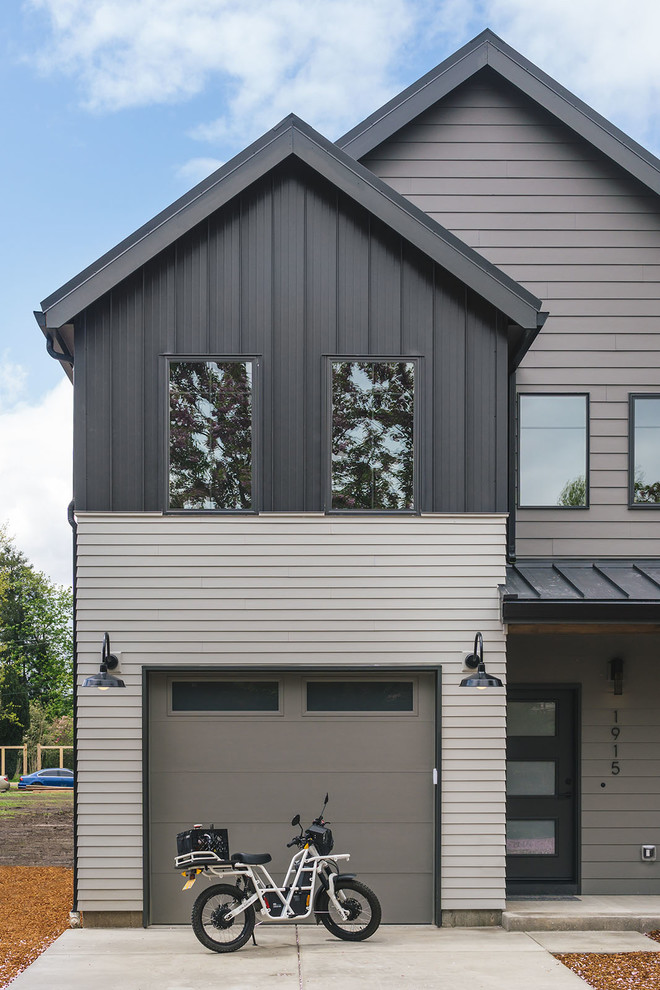 Cette image montre une petite façade de maison noire rustique en panneau de béton fibré à un étage avec un toit à deux pans et un toit en métal.