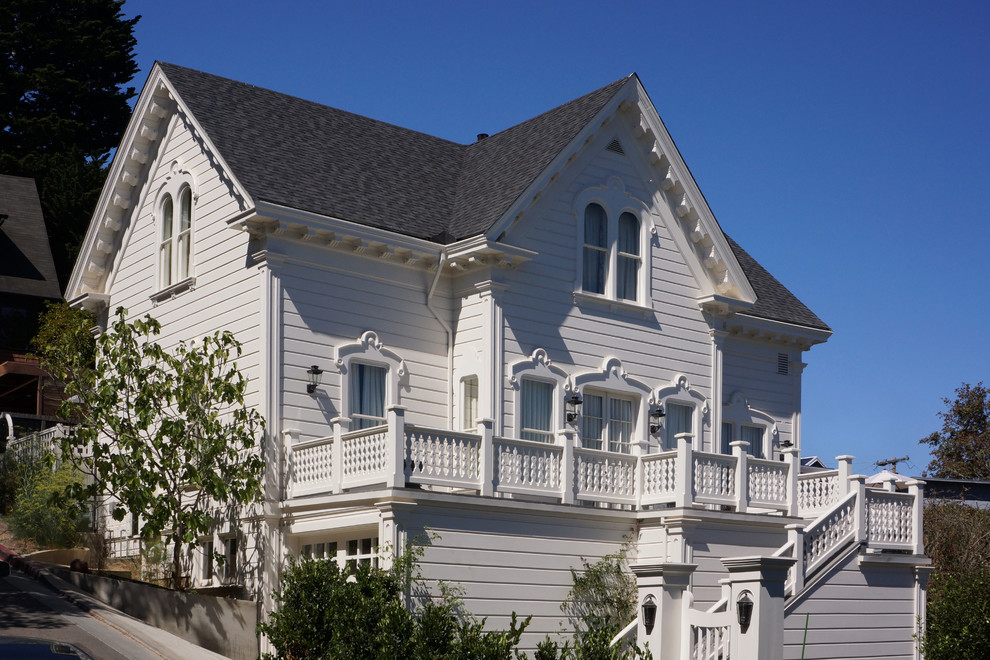 Esempio della facciata di una casa bianca vittoriana a due piani di medie dimensioni con rivestimento in legno
