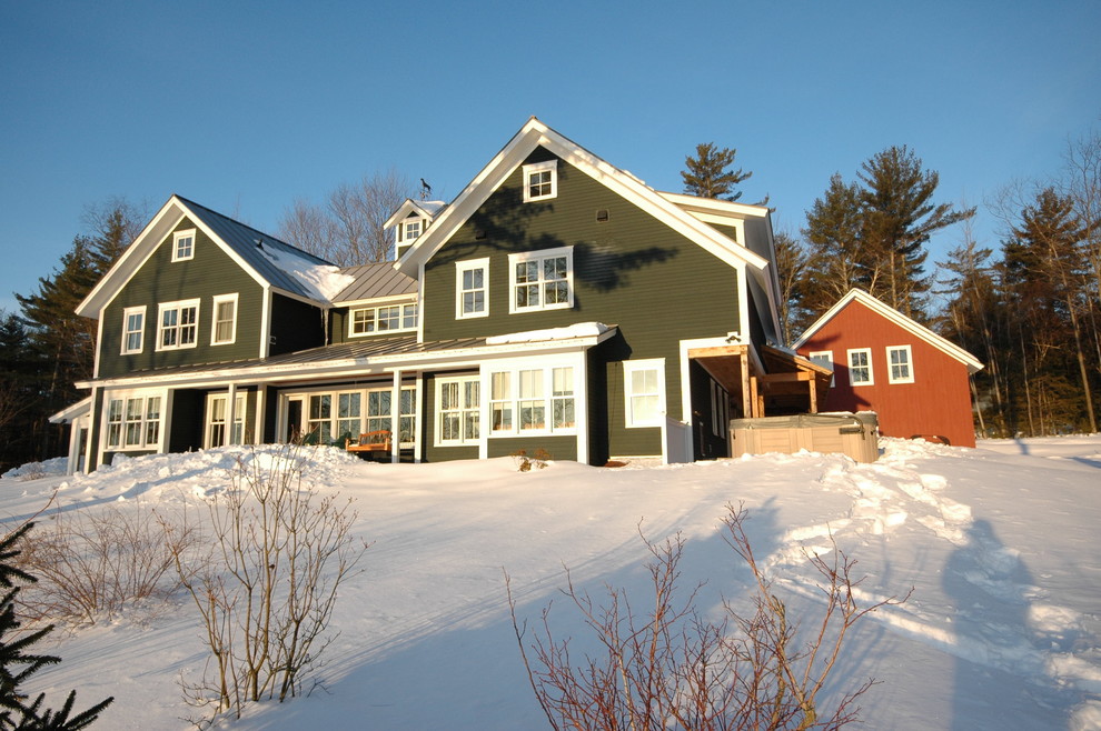 Exemple d'une grande façade de maison verte nature à un étage avec un revêtement mixte, un toit à deux pans et un toit en métal.