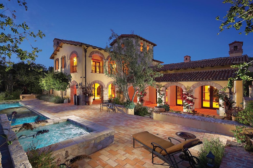 Mittelgroßes, Zweistöckiges Mediterranes Einfamilienhaus mit Satteldach, Steinfassade, grauer Fassadenfarbe und Ziegeldach in Orange County