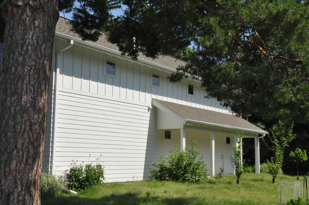 Kleines, Zweistöckiges Landhausstil Haus mit Mix-Fassade, weißer Fassadenfarbe und Satteldach in Omaha