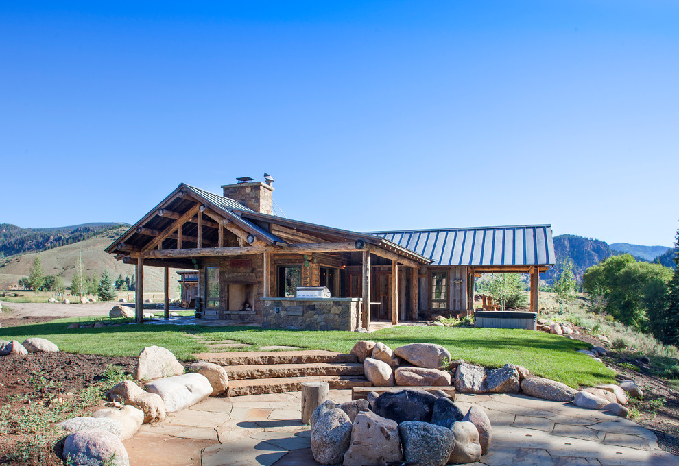 This is an example of a rustic bungalow house exterior in Denver with wood cladding and a pitched roof.