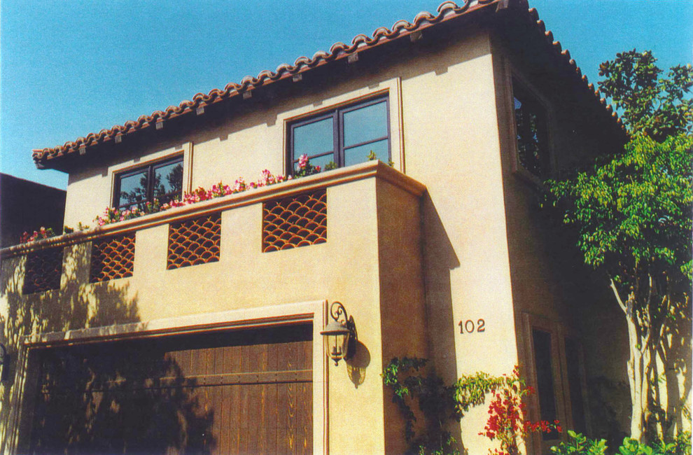 Idee per la facciata di una casa grande beige mediterranea a due piani con rivestimento in stucco e tetto piano