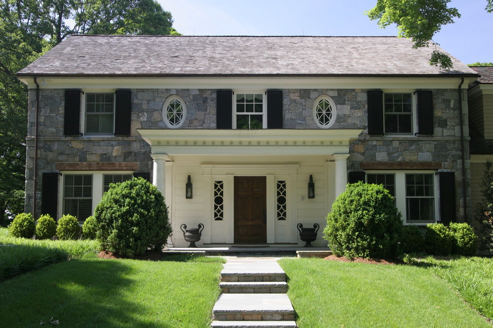 Esempio della facciata di una casa classica con rivestimento in pietra