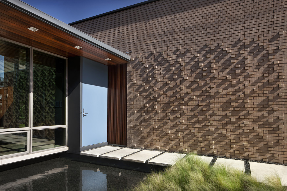 Ispirazione per la facciata di una casa moderna con rivestimento in mattoni