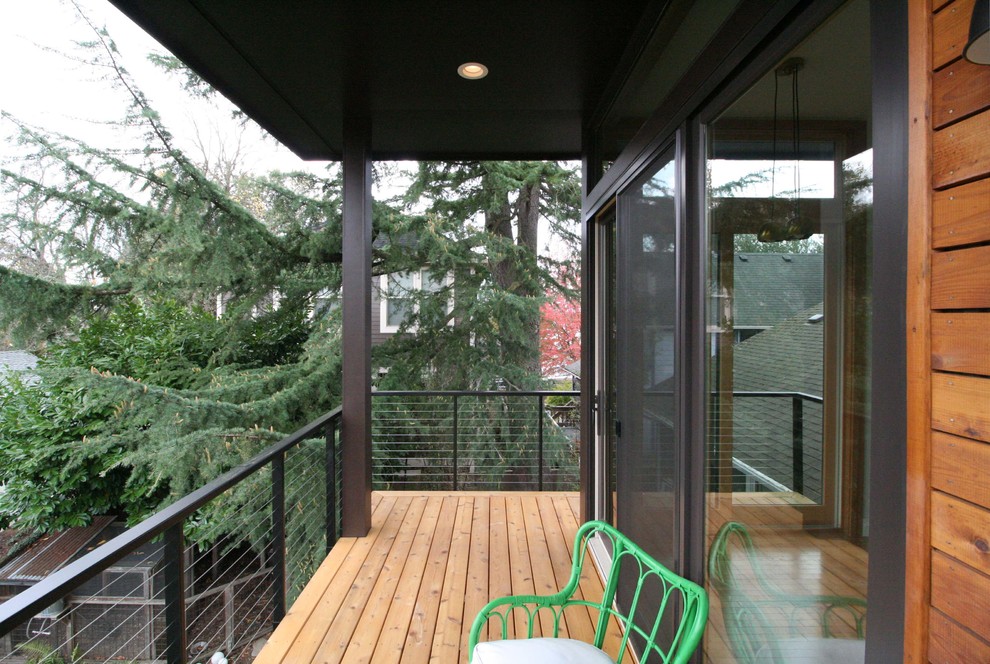 Modelo de fachada de casa azul minimalista de tamaño medio de dos plantas con revestimiento de madera y tejado de un solo tendido