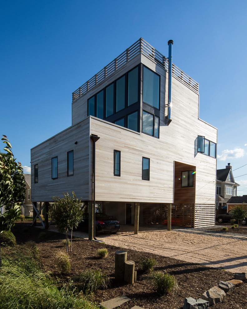 Foto de fachada de casa minimalista de tres plantas con revestimiento de madera y tejado plano