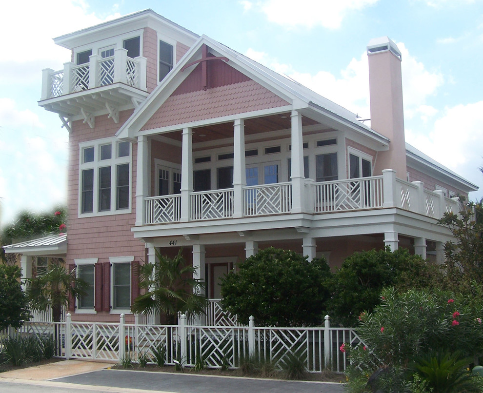 Design ideas for a world-inspired house exterior in Jacksonville with a pink house.