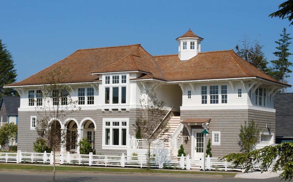 Ejemplo de fachada gris de estilo de casa de campo de tamaño medio de dos plantas con revestimientos combinados y tejado a cuatro aguas