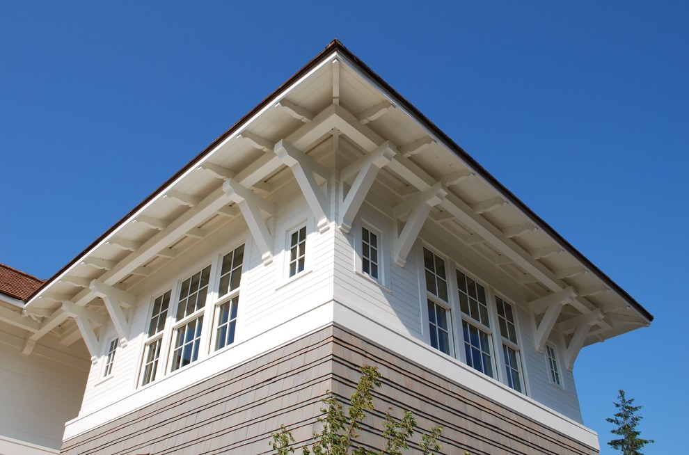 Aménagement d'une façade de maison grise bord de mer de taille moyenne et à un étage avec un revêtement mixte.