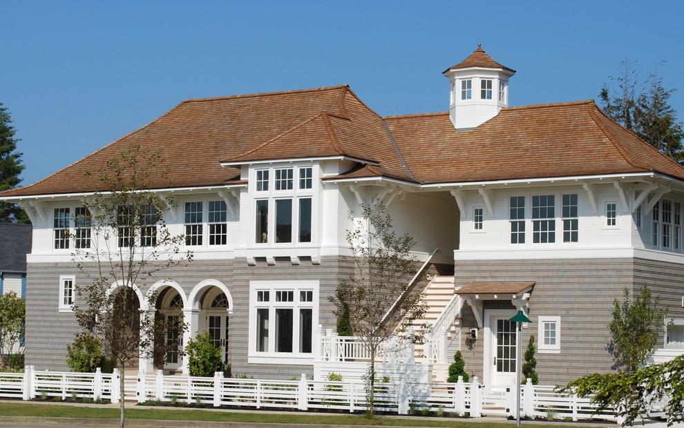 На фото: огромный, двухэтажный, деревянный дом в морском стиле с вальмовой крышей