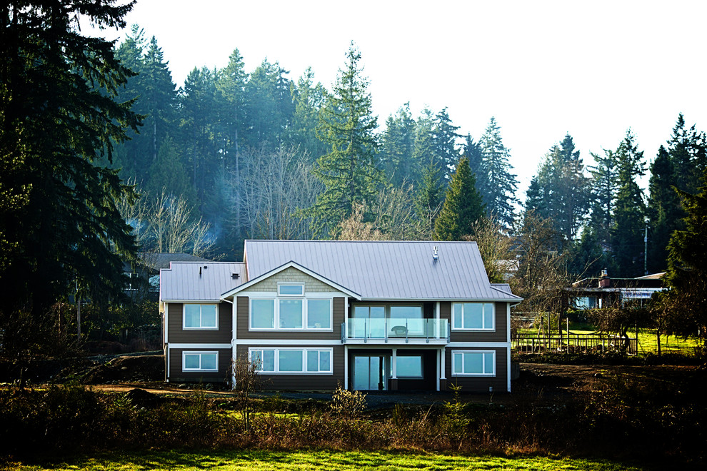 Стильный дизайн: большой, двухэтажный, коричневый частный загородный дом в стиле модернизм с облицовкой из ЦСП и металлической крышей - последний тренд