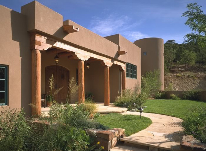 Design ideas for a large and brown traditional clay house exterior in Albuquerque with three floors and a flat roof.