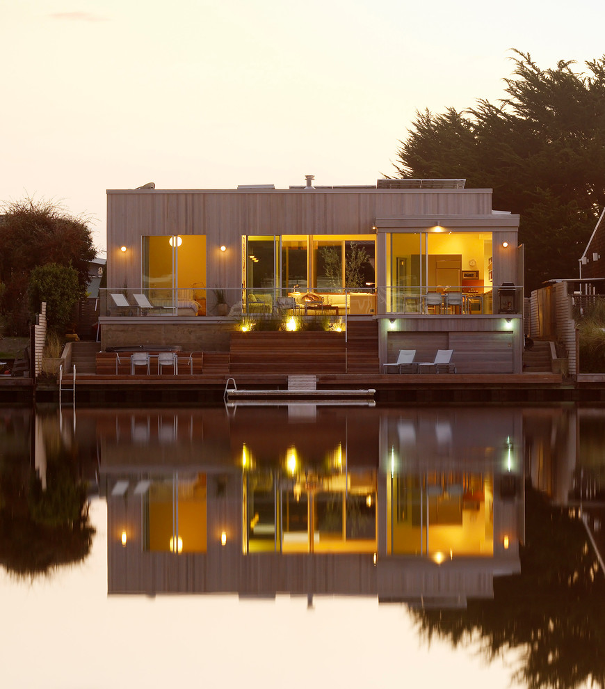 На фото: маленький, одноэтажный, коричневый дом в морском стиле для на участке и в саду