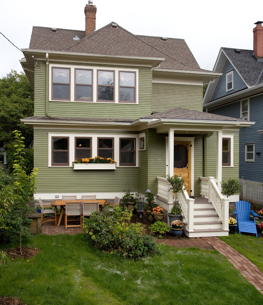 Imagen de fachada de casa verde clásica de dos plantas con tejado a dos aguas y tejado de teja de madera
