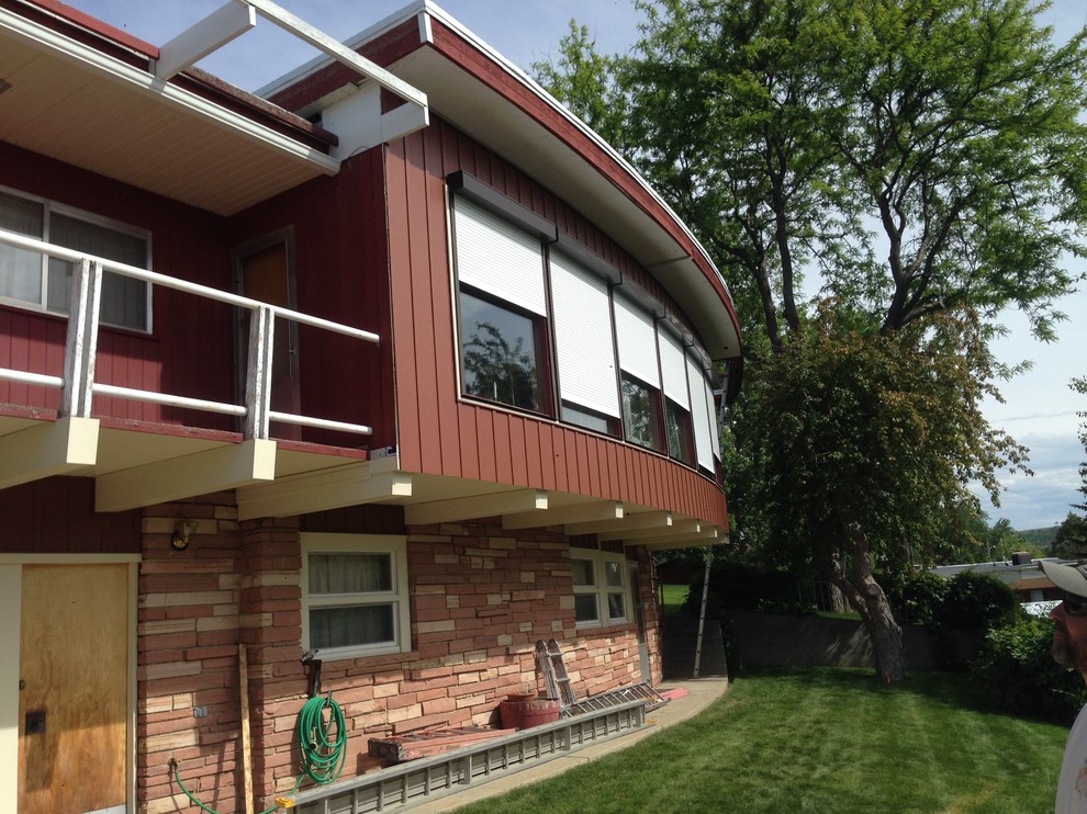 Exemple d'une grande façade de maison rouge tendance en panneau de béton fibré à un étage avec un toit plat.