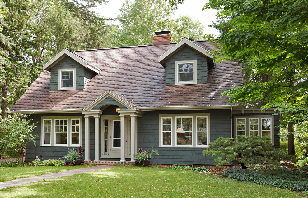 Inspiration pour une façade de maison verte chalet en bois de taille moyenne et à un étage avec un toit à croupette et un toit en shingle.