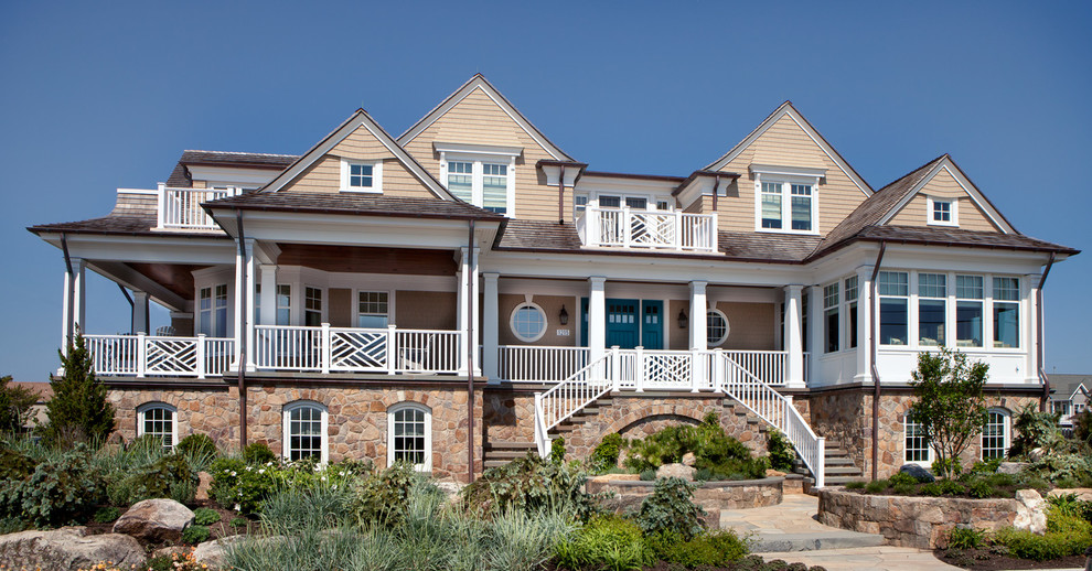 Cette photo montre une grande façade de maison beige bord de mer à deux étages et plus avec un revêtement mixte, un toit à deux pans et un toit en shingle.