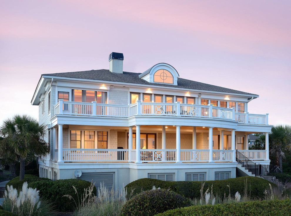 Cette image montre une façade de maison grise marine à un étage avec un toit à quatre pans et un toit en shingle.