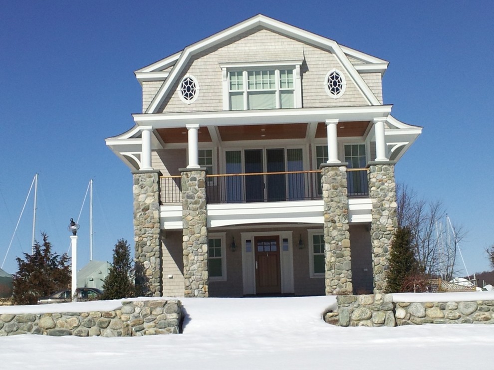 Ejemplo de fachada de casa beige costera de tamaño medio de tres plantas con revestimiento de madera, tejado a doble faldón y tejado de teja de barro