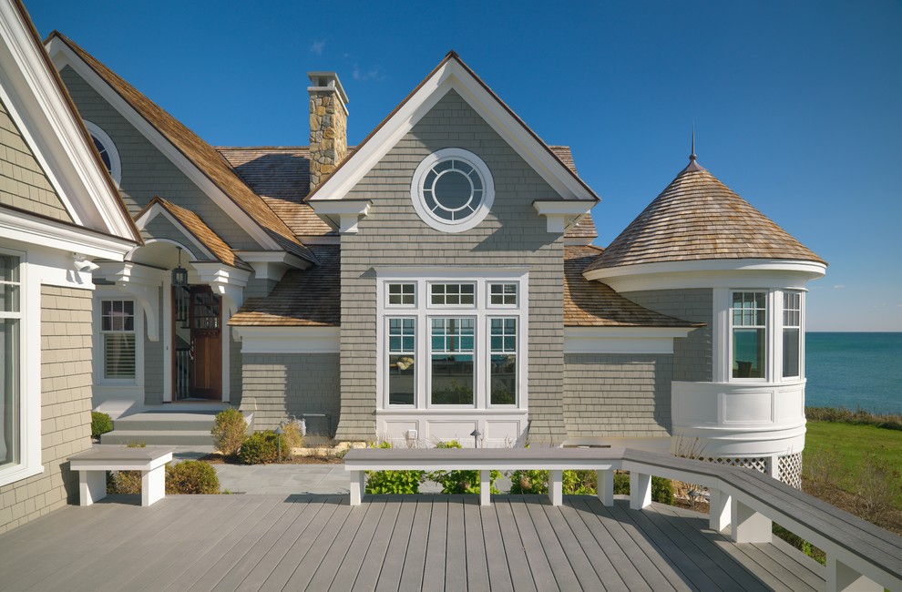 Стильный дизайн: серый, большой, двухэтажный, деревянный частный загородный дом в викторианском стиле с двускатной крышей и крышей из гибкой черепицы - последний тренд