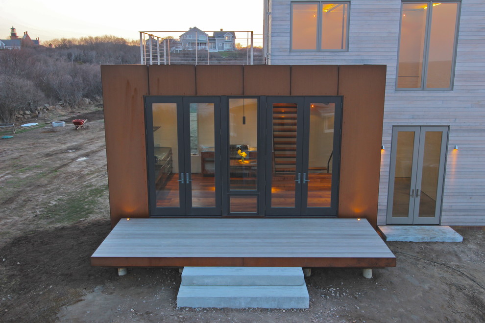Пример оригинального дизайна: маленький дом в стиле модернизм с разными уровнями и комбинированной облицовкой для на участке и в саду