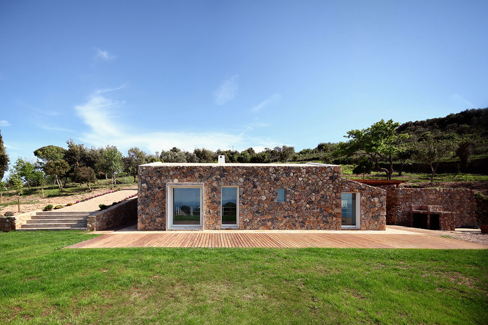 Cette photo montre une petite façade de petite villa méditerranéenne en pierre avec un toit plat.