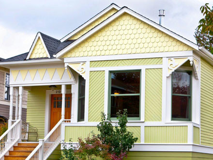 Ispirazione per la facciata di una casa piccola gialla vittoriana a due piani con tetto a capanna e rivestimento in legno