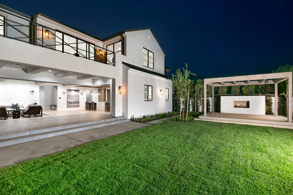 На фото: большой, двухэтажный, белый частный загородный дом в стиле модернизм с облицовкой из цементной штукатурки и металлической крышей с