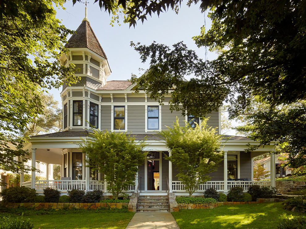 Idées déco pour une façade de maison grise classique à un étage avec un toit à quatre pans.