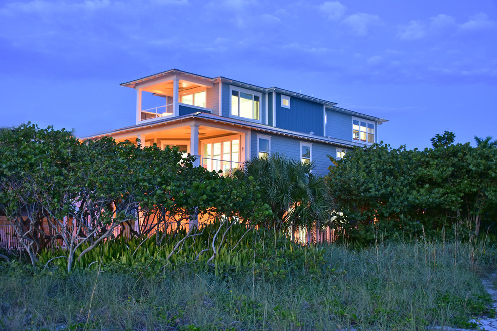 На фото: большой, деревянный, синий, трехэтажный дом в морском стиле с вальмовой крышей с