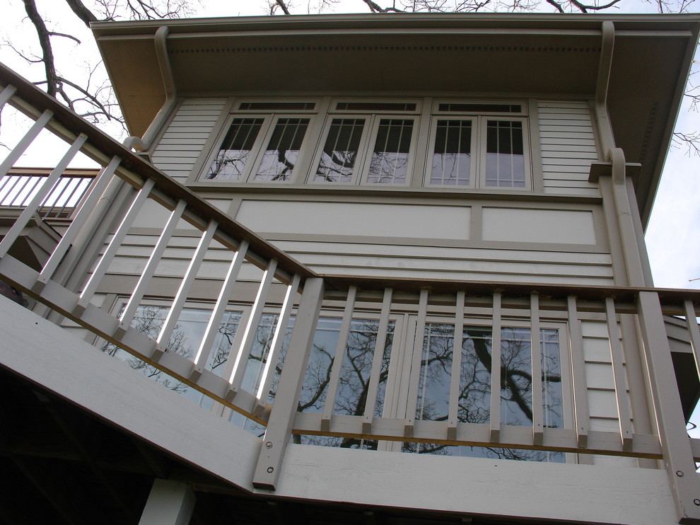 Modelo de fachada de casa beige clásica grande de tres plantas con revestimiento de aglomerado de cemento