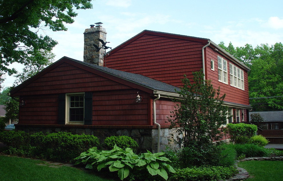 Imagen de fachada de casa roja retro de tamaño medio de dos plantas con revestimientos combinados y tejado a dos aguas