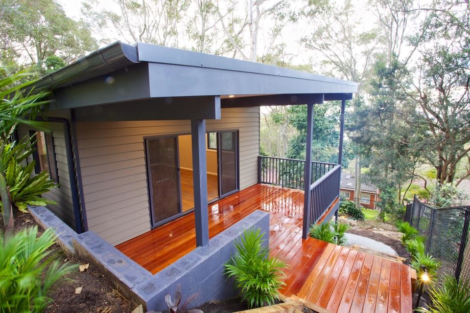 This is an example of a small and beige modern bungalow house exterior in Sydney with wood cladding.