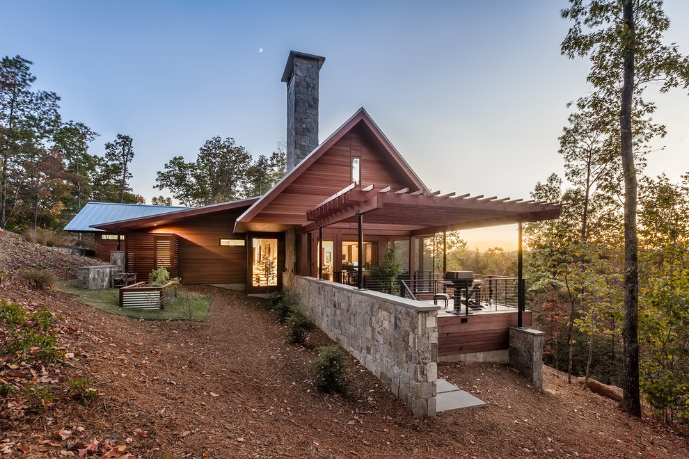 Idee per la villa grande marrone rustica a due piani con tetto a capanna, rivestimento in legno e copertura in metallo o lamiera