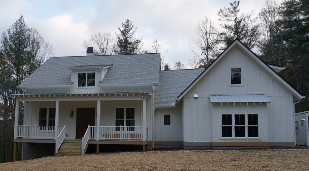На фото: одноэтажный, деревянный, белый частный загородный дом среднего размера в стиле кантри с двускатной крышей и крышей из смешанных материалов с