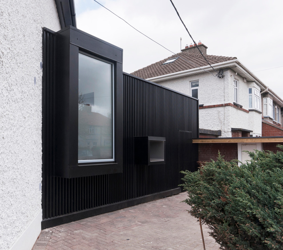 Cette image montre une façade de maison noire design de plain-pied.