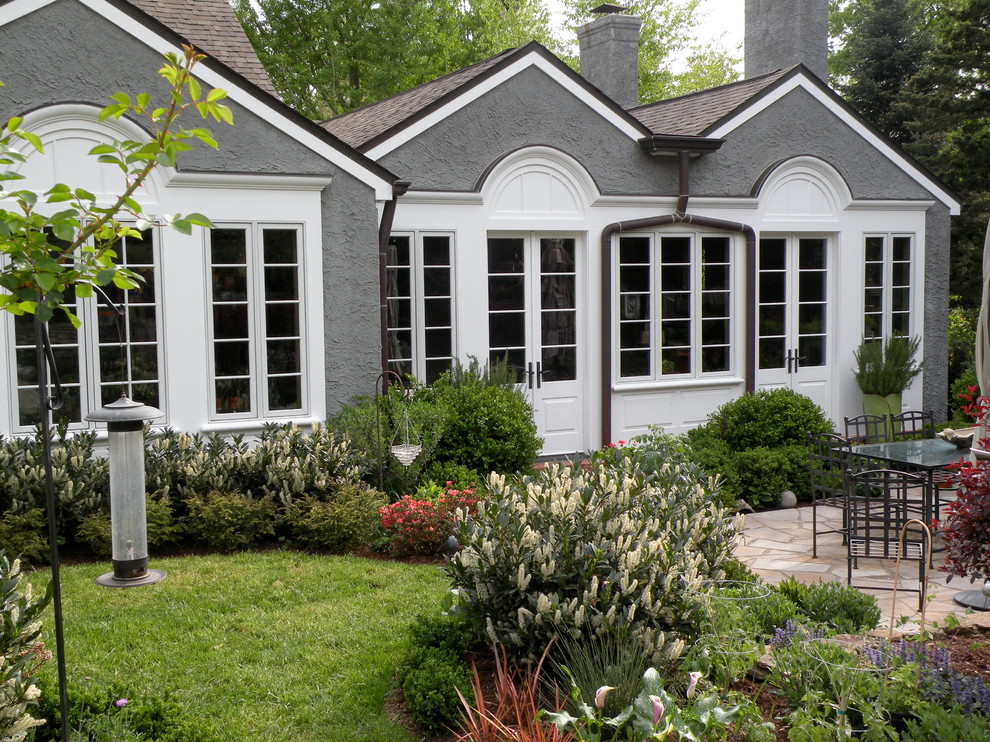 Exemple d'une façade de maison grise chic en stuc de taille moyenne et de plain-pied.