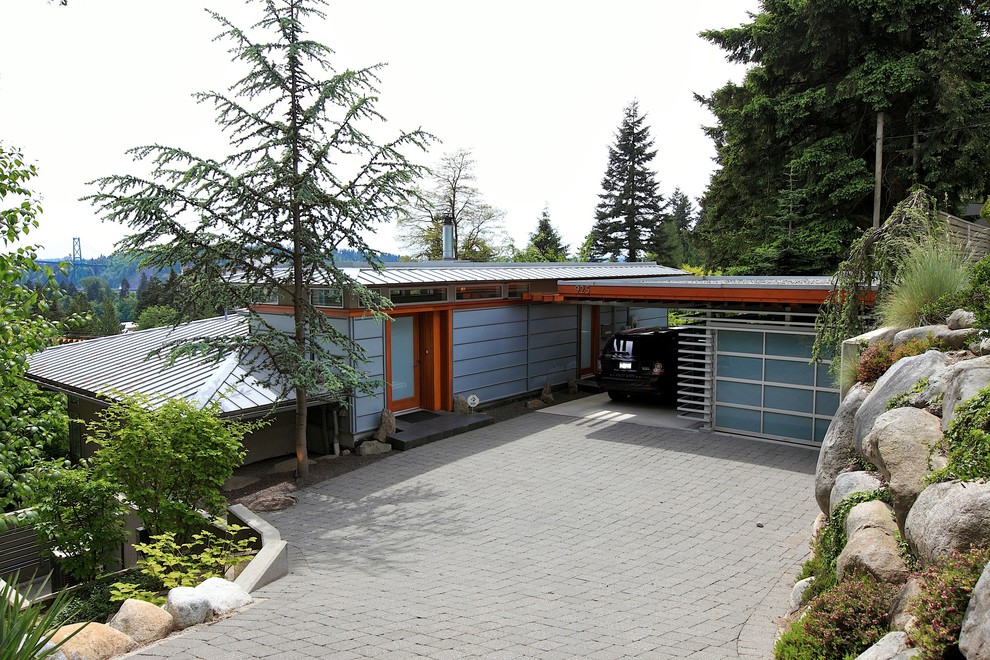 Medium sized and blue modern bungalow house exterior in Vancouver with metal cladding.