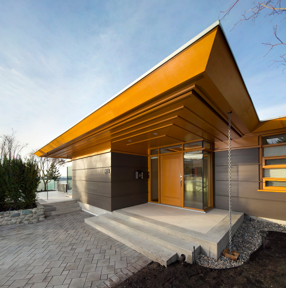 Idee per la facciata di una casa ampia marrone contemporanea a un piano con rivestimento in vetro e tetto piano