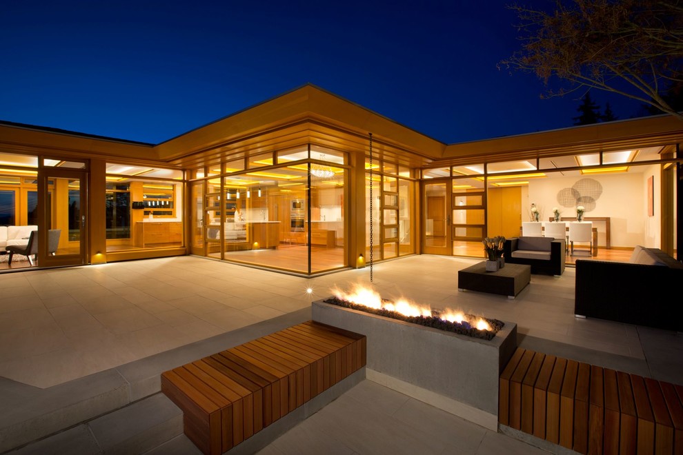 Réalisation d'une très grande façade de maison marron design en verre de plain-pied avec un toit plat.