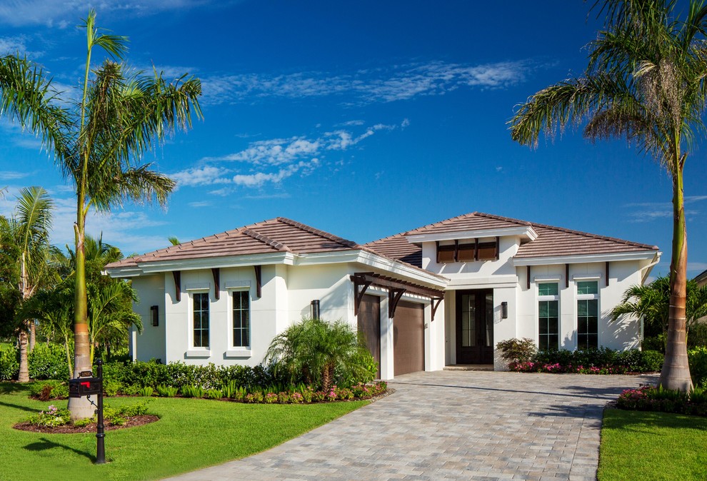 Photo of a medium sized and white world-inspired bungalow detached house in Miami with a tiled roof and a hip roof.