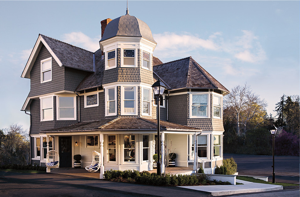 Foto de fachada de casa gris clásica grande de tres plantas con revestimientos combinados y tejado de teja de madera