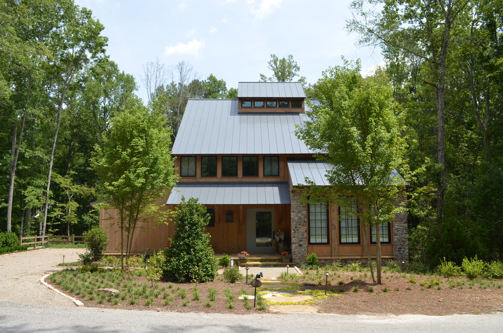 Lantlig inredning av ett mellanstort brunt hus, med två våningar, blandad fasad och valmat tak