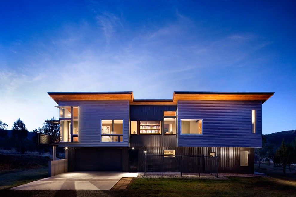 На фото: большой, двухэтажный, серый дом в современном стиле с облицовкой из металла