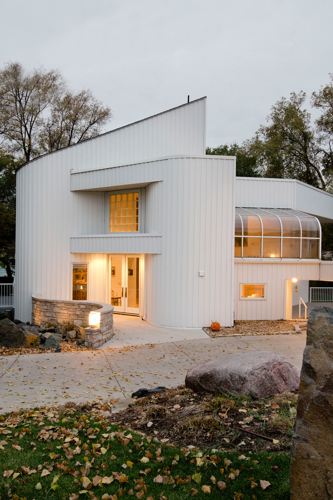 Réalisation d'une façade de maison blanche minimaliste à un étage.