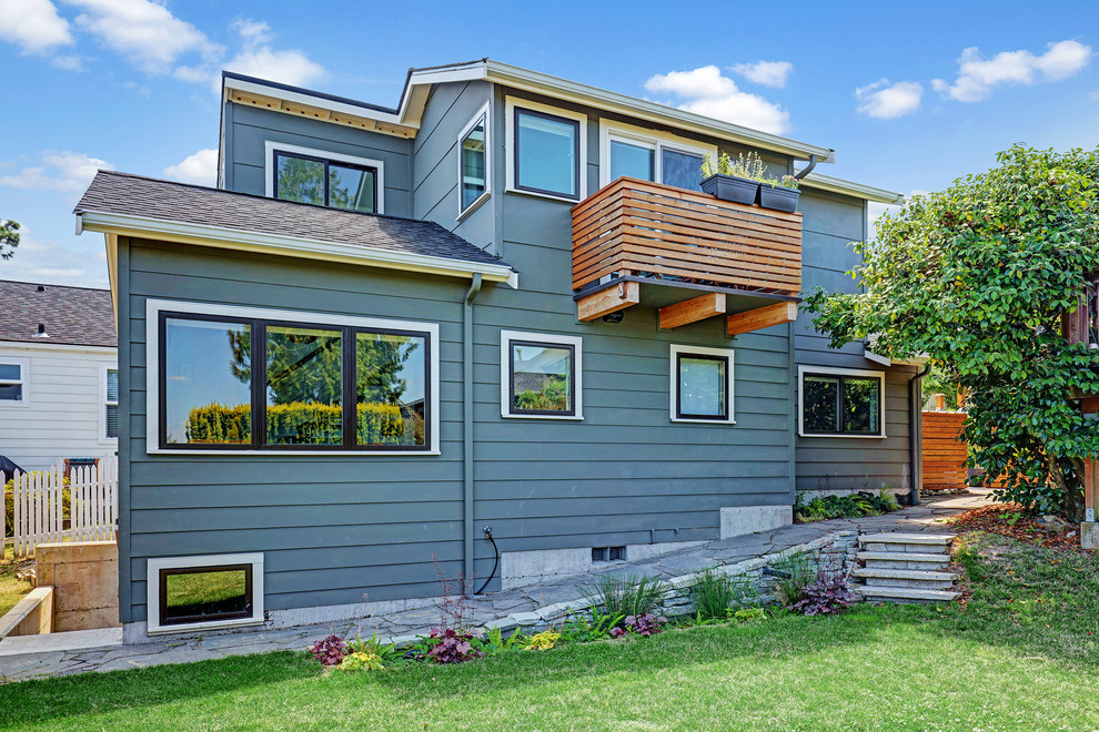 Cette photo montre une petite façade de maison verte chic en panneau de béton fibré à un étage avec un toit à deux pans et un toit en shingle.