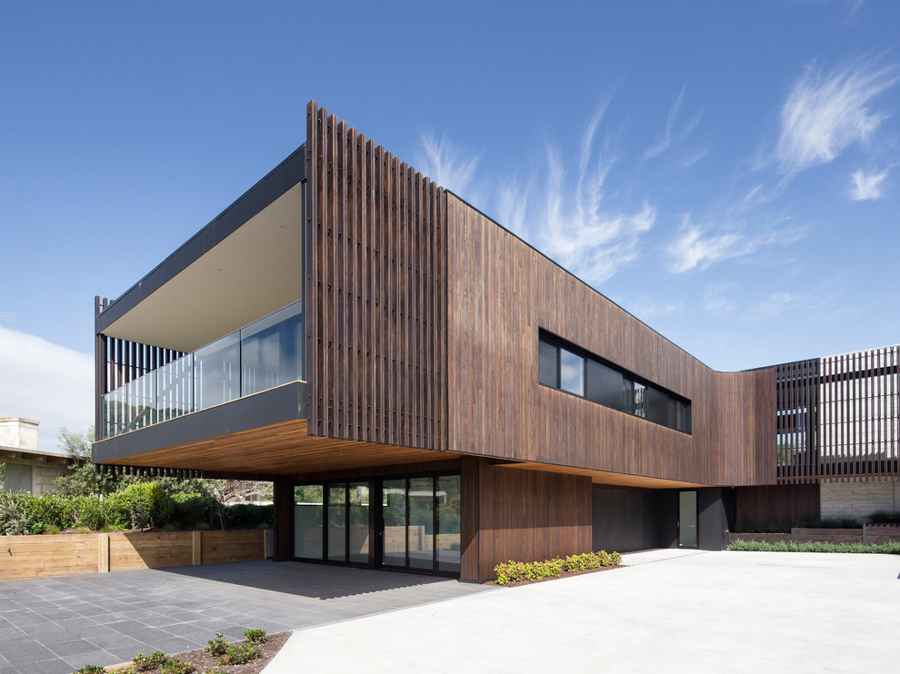 Imagen de fachada de casa marrón moderna grande de dos plantas con revestimiento de madera y tejado plano