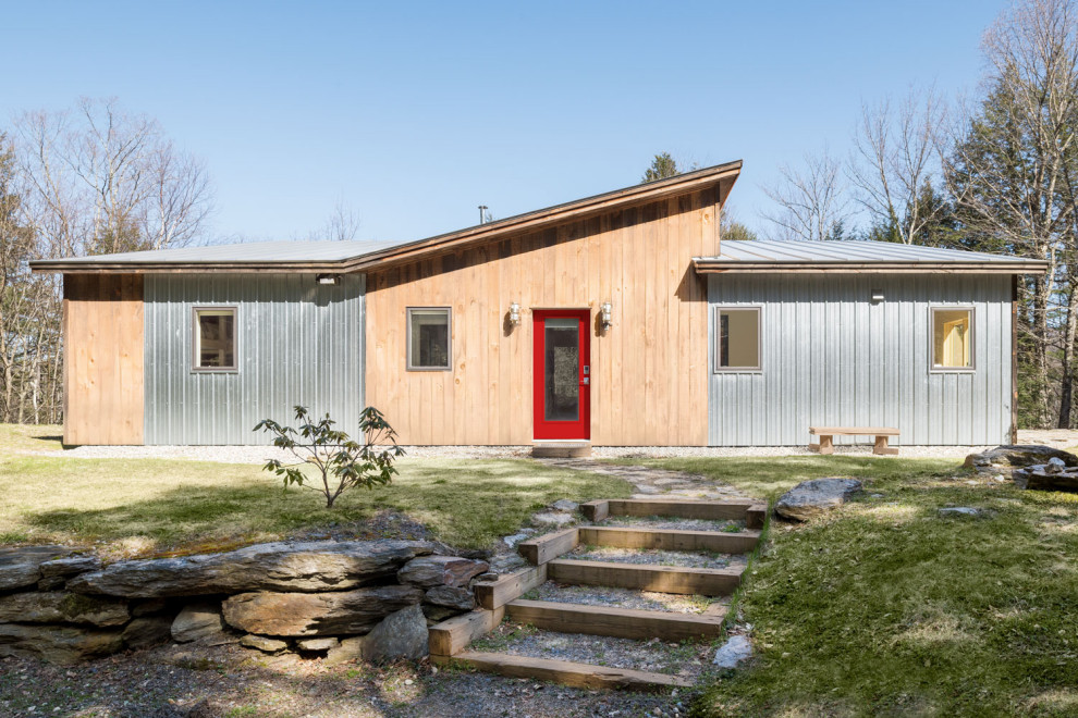 Aménagement d'une petite façade de Tiny House métallique industrielle de plain-pied avec un toit papillon et un toit en métal.